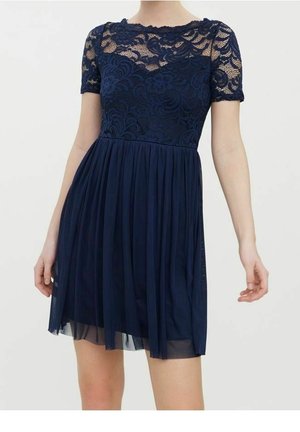 Robe bleu marine avec corsage en dentelle florale, manches courtes, encolure transparente, et jupe plissée fluide au-dessus du genou.