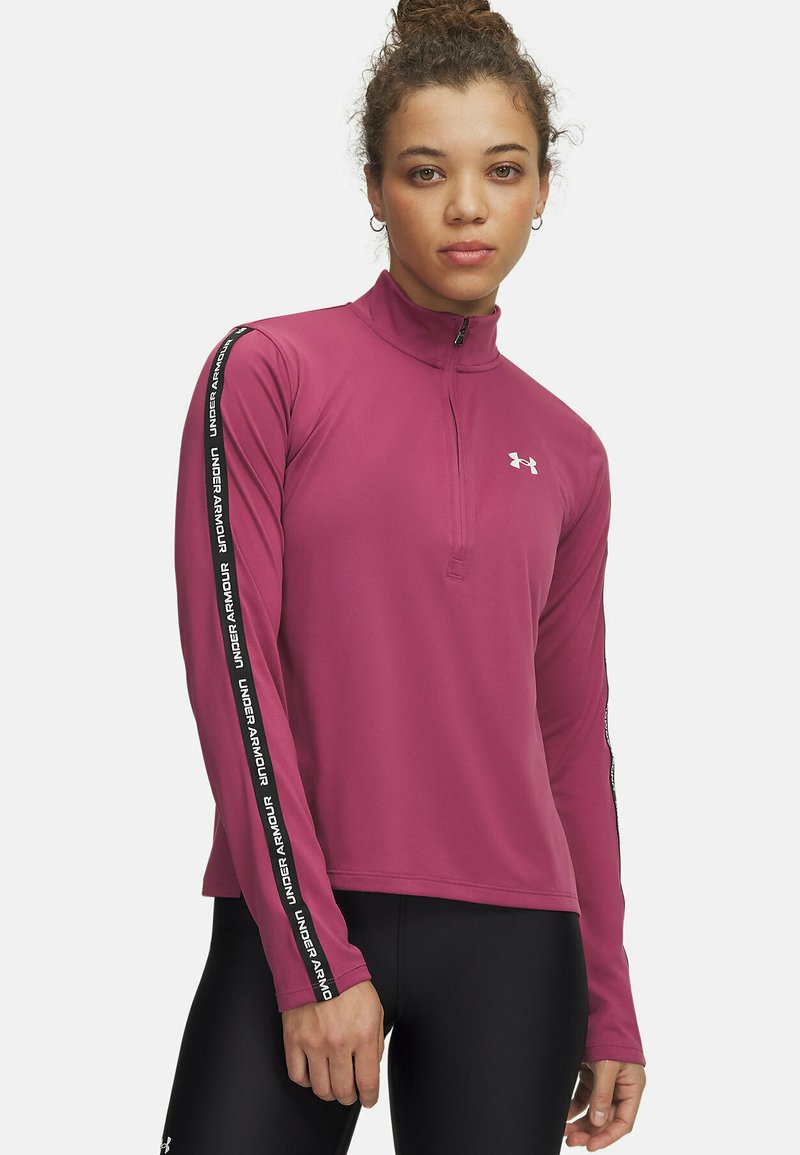 Fitted long-sleeve pullover in deep pink with a quarter zip, featuring black side stripes inscribed with "Under Armour" logo. Smooth fabric texture.
