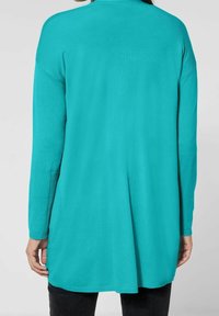 Långärmad, löst sittande tröja i ljus turkos, med ribbad krage och muddar, tillverkad av mjukt, texturerat stickat tyg.