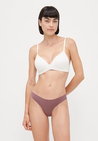 Witte bh met een gladde afwerking en verstelbare bandjes, gecombineerd met mauve bikini slipjes, met een lage taille en naadloze randen.