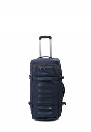 Valise roulante bleu foncé avec poignée prolongée, plusieurs compartiments zippés et sangles latérales, debout sur fond blanc.