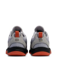 Grijze en zwarte sportschoenen met een bovenwerk van mesh, rode accenten en een gestructureerde zool. Voorzien van een trekband op de hiel voor eenvoudig aandoen.