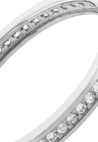 Bague en argent avec un anneau lisse comprenant une rangée de petites pierres claires serties en canal le long de la surface, présentant un design élégant.