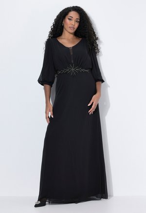 Zwarte maxi-jurk met een vloeiende Silhouet, transparante inzet bij de halslijn en een met kralen versierde accent bij de taille. Lange, luchtige mouwen.