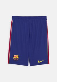 Pantaloni sportivi blu con logo Nike giallo, dettagli laterali rossi e un ricamo dello stemma del FC Barcelona in basso a sinistra. Vita elastica.