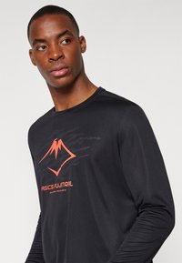 Schwarz langärmliges Sportshirt mit einem orangefarbenen Berge-Logo und Markentext. Glatte Textur mit Rundhalsausschnitt.