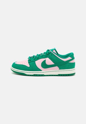 Niskie buty sportowe Nike z zielonego zamszu i różowej skóry z zielonymi sznurówkami i białą podeszwą, pokazane z boku na białym tle.