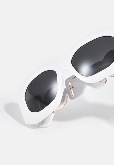 Ochelari de soare albi, supradimensionați, cu un design geometric, lentile închise la culoare și accente aurii pe laturi. Rame din plastic neted, cu un finisaj lucios.