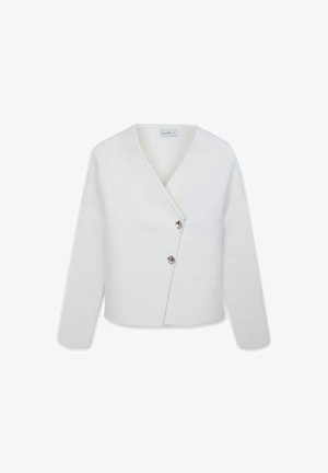 Top en tricot blanc à encolure cache-cœur avec des manches longues, présentant un décolleté en V profond et deux boutons métalliques à l'avant. Texture lisse, design minimal.