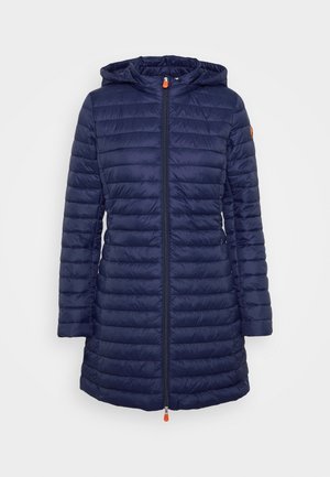 Veste longue matelassée bleu marine avec capuche, fermeture éclair frontale avec tirettes orange et manches longues, conçue pour le temps froid.