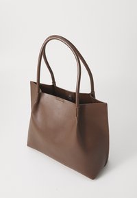 Barna bőr tote táska két ívelt fogantyúval és patentos záródással. Simaság jellemzi, valamint minimalista dizájnja van.