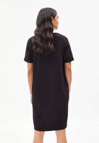 Robe noire à manches courtes avec une coupe décontractée, en tissu lisse, longueur au-dessus du genou et détails de poignets roulés. Design simple et uni.