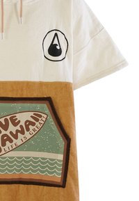 T-shirt a maniche corte in cotone con parte superiore bianca, sezione inferiore marrone, logo e una grafica in stile retro su sfondo teal con onde.