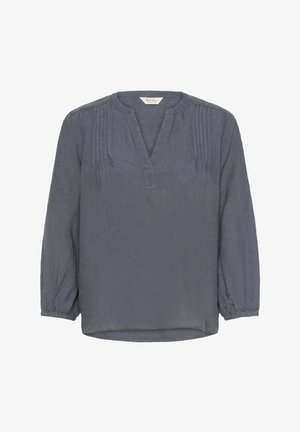 Blouse en lin gris à manches longues, avec un col en V, des détails plissés sur les épaules et des poignets élastiques. Ourlet légèrement arrondi.
