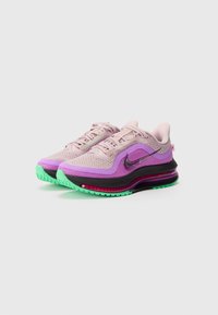 Chaussures de sport violettes et roses avec une tige en mesh, des accents noirs, un coussin d'air visible, et une semelle en caoutchouc verte. Comprend des lacets et un logo.