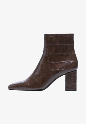 Bottine en cuir marron foncé avec texture crocodile, bout pointu et talon bloc.