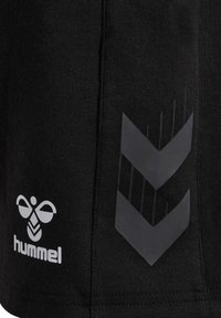 Schwarze Sportshorts aus strukturiertem Stoff mit einem weißen Logo und einem grauen Chevron-Muster an der Seite.