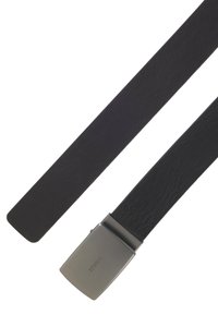 Cinturón de cuero negro con una textura suave, que cuenta con una hebilla rectangular en tono plateado con el nombre de la marca grabado.