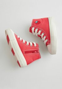 Czerwone sneakersy za kostkę z płótna z białymi sznurówkami i gumową podeszwą; posiadają boczny zamek błyskawiczny oraz haftowany wzór truskawki.