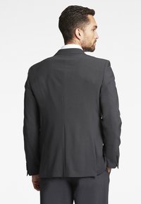 Grijze op maat gemaakte pak met een enkele split en notch revers, met een gladde textuur, lange mouwen en knoopmanchetten.