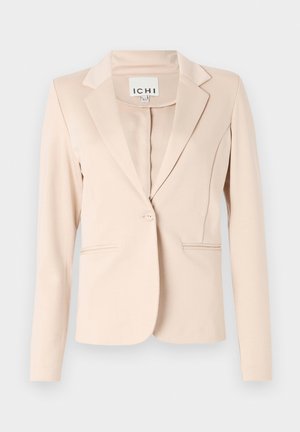 Šviesiai rudas vienspalvis švarkas su viena saga, su įpjovomis atlapuose, ilgomis rankovėmis ir dviem priekinėmis kišenėmis, kabantis priešais vientisą foną.