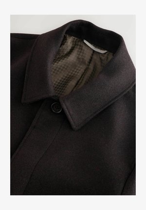 Juodas vilnos paltas su apykakle, užsegamas viena kniedė, ir raštuota alyvuogių žalios spalvos pamušalu. Lygus paviršius, siuvimo pritaikymas.