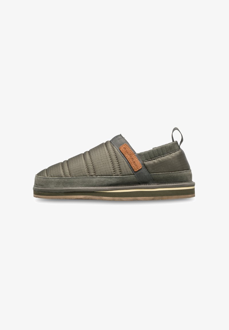Chaussure slip-on avec un dessus matelassé gris-vert à la surface texturée, une bande d'accent brun et une semelle en caoutchouc arrondie.