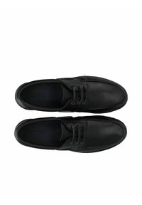 Chaussures en cuir noir avec une finition texturée, bout rond et lacets. Présentent des coutures discrètes et une doublure intérieure foncée.