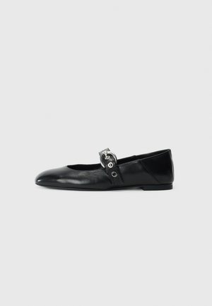 Mocasines de ballet de cuero negro con punta afilada, que cuentan con una correa con un cinturón metálico circular y una suela plana.