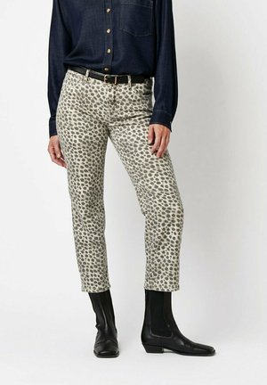 Leopard-print cotton pants with a slim fit and ankle length, paired with a navy button-up shirt and black ankle boots.
