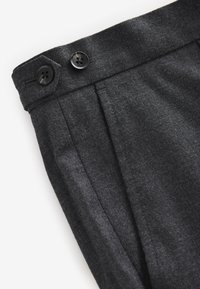 Dark gray trousers made of textured fabric with two buttons on the waistband and front pleats, showcasing a tailored design.