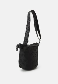 Borsa a spalla nera con motivo floreale, tracolla regolabile, chiusura con zip e texture liscia. Forma rotonda con dettaglio del logo alla base.