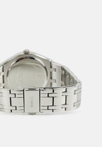 Orologio in acciaio inox argentato con cassa rettangolare, bracciale a maglie metalliche e finitura lucida. Dotato di una chiusura con logo.