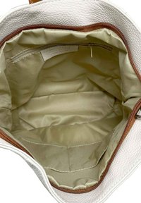 Vit, texturerad läderväska med en beige interiör. Har en dragkedjestängning och flera fack för organisering.