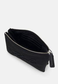 Black nylon pouch with textured logo detail, silver zipper closure, and fabric interior featuring card slots. Compact rectangular shape.