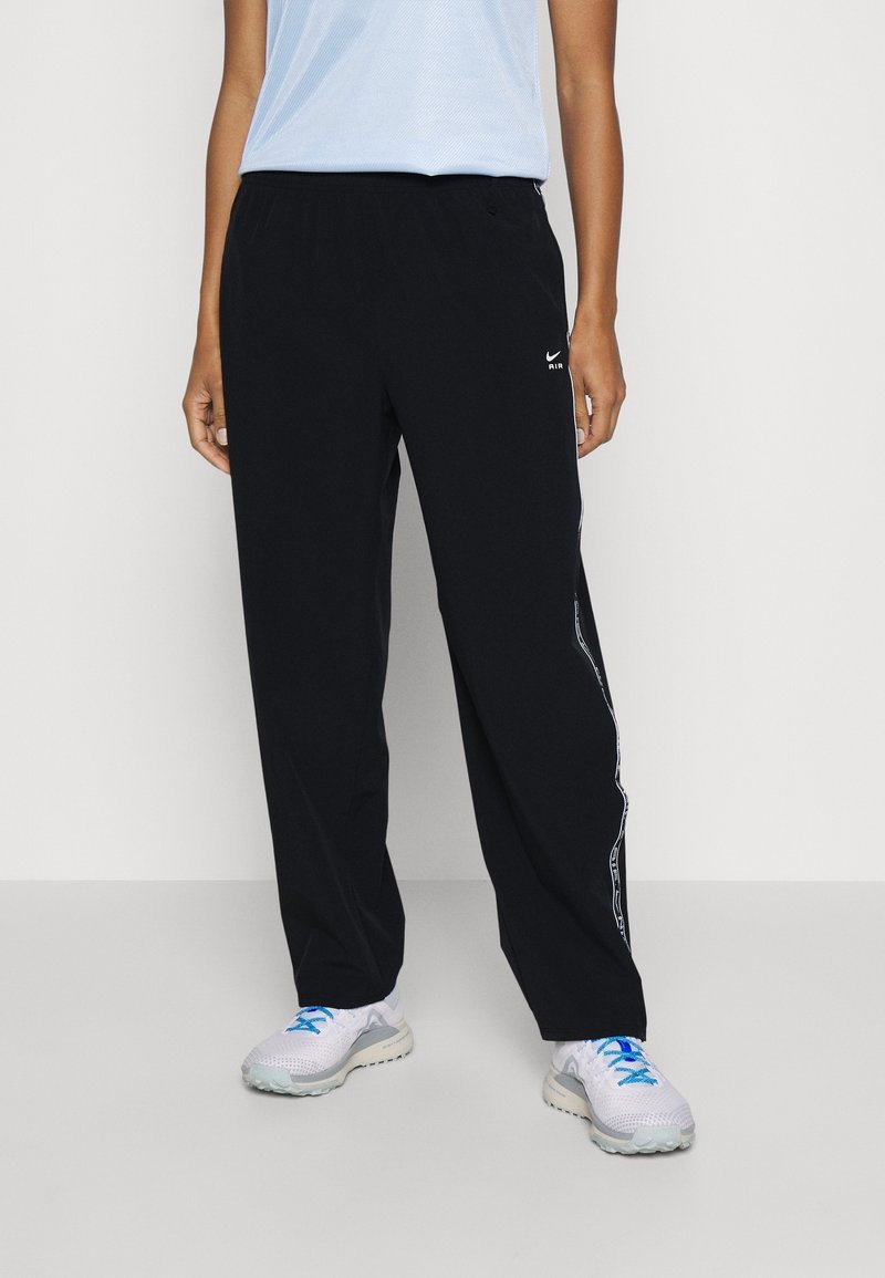 Sorte træningsbukser med løst fit, detaljer med sidelogo og et lille hvidt logo foran. Kombineret med lyse sneakers.