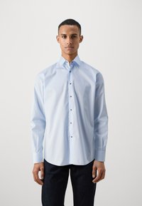 Hellblaues Langarmhemd aus Baumwollstoff. Mit einem normalen Kragen, durchgehender Knopfleiste und schwarzen Knöpfen. Gerader Saum.