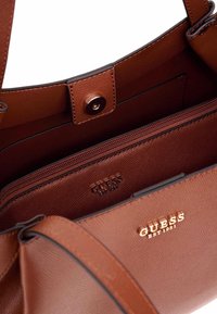 Sac à main en simili cuir marqué de couleur marron, avec une fermeture à pression magnétique, une poche zip intérieure et des détails en logo doré embossé.