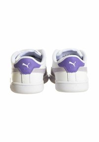 Scarpe sportive bianche con un accento viola sul tallone, dotate di un colletto imbottito e dettagli testurizzati sui lati.