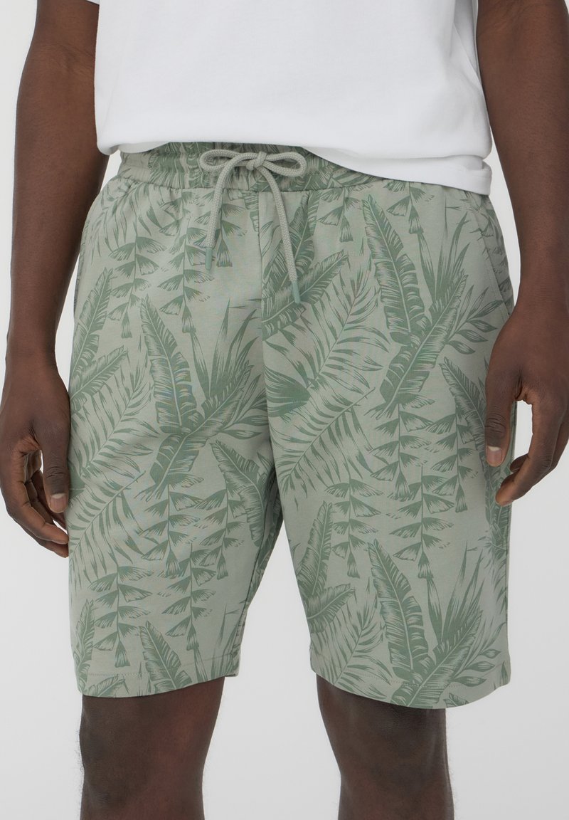 Shorts verde chiaro con motivo a foglie di palma, vita elastica con coulisse e vestibilità casual, realizzati in un tessuto morbido e traspirante.