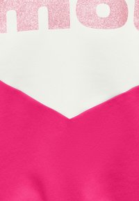 Cheerful shirt with bright pink and white chevron design and glittery pink partial text on upper section.