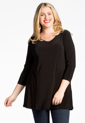 Tunique noire avec un décolleté en V et des manches trois-quarts, fabriquée dans un tissu doux, présente une coupe décontractée et tombe au-dessus des hanches. Design minimaliste.
