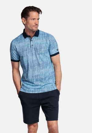 Polo-shirt à manches courtes bleu clair avec un motif texturé, col marine et accents de manches, associé à un short sombre.