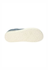 Suola della sneaker in materiale gommoso bianco, caratterizzata da un motivo a onda per la trazione, con una tomaia in tessuto blu chiaro visibile ai bordi.