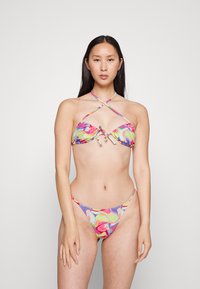 Top de bikini colorido com bordas onduladas e detalhe de nó, juntamente com um fundo de bikini minimalista correspondente, apresenta um padrão abstrato em espirais em cores vibrantes.