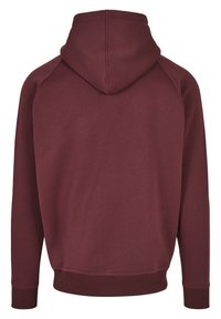 Burgundy huppari, jossa on sileä pinta, raglan-hihat ja resorit helmassa ja hihoissa; ei etutaskuja tai näkyvää brändäystä.