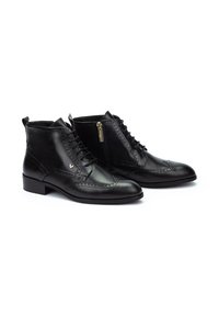 Botines de cuero negro con punta redonda, cierre con cordones en la parte delantera, detalles decorativos de brogue y una cremallera lateral para un fácil acceso.
