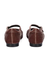 Zapatos de terciopelo marrón con forma redondeada, correa trasera y suela de goma negra. Textura suave con un ligero brillo y detalles de costura.