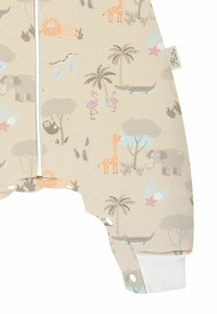 Kinder-Overall aus beigem Stoff mit bunten Tiermotiven, darunter Elefanten, Giraffen und Flamingos. Weiße Bündchen und ein Reißverschluss.