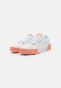White sneakers with a ridged pink sole, leather upper, rounded toe, and tonal laces. Gold Puma logo on the side and tongue.